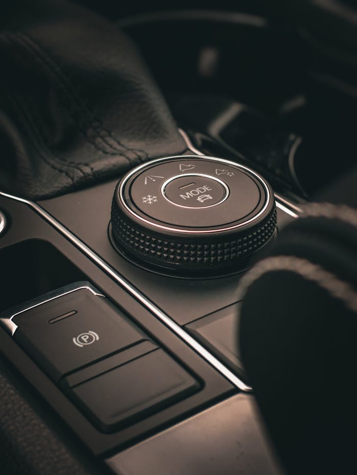 pexels-photo-14079685 Close-up of a luxurious car interior control knob, highlighting modern automotive design.
